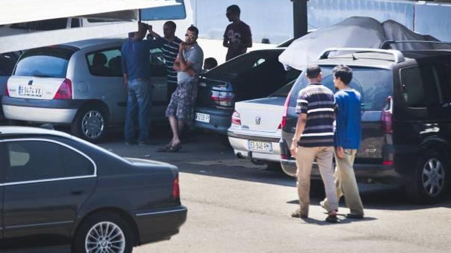 Los viajeros se refugiaban del calor y el sol en la zona de aparcamiento.