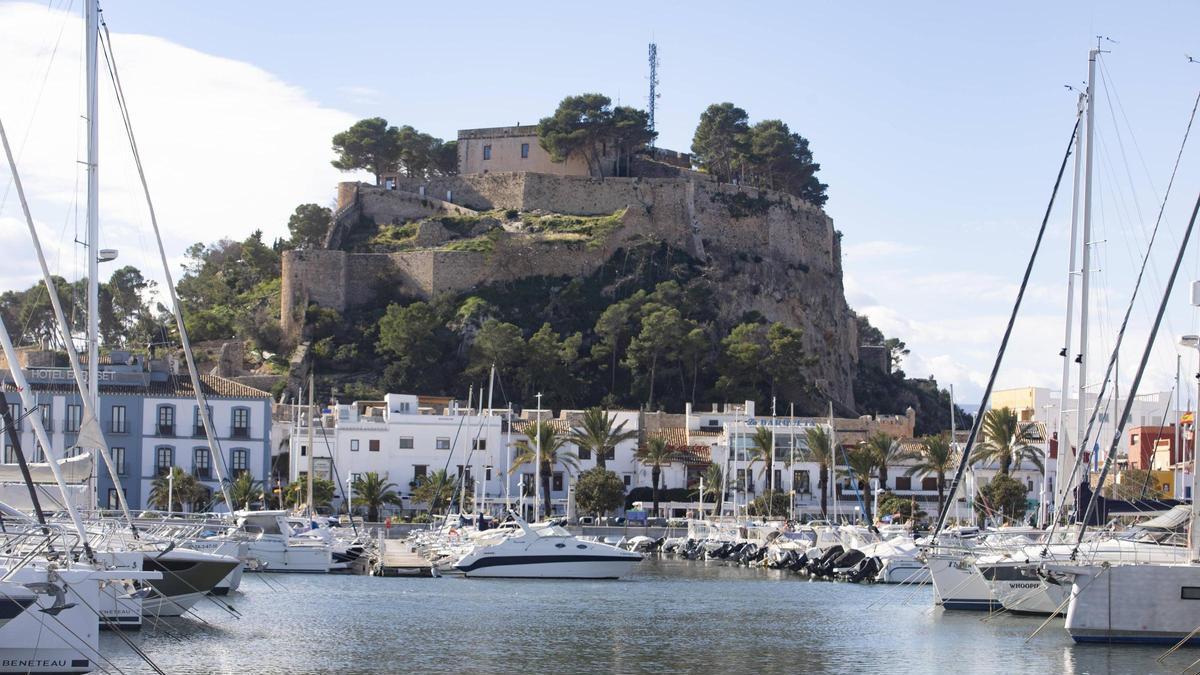 Embarcaciones en el puerto de Dénia, con la silueta del castillo de la ciudad, al fondo de la imagen.