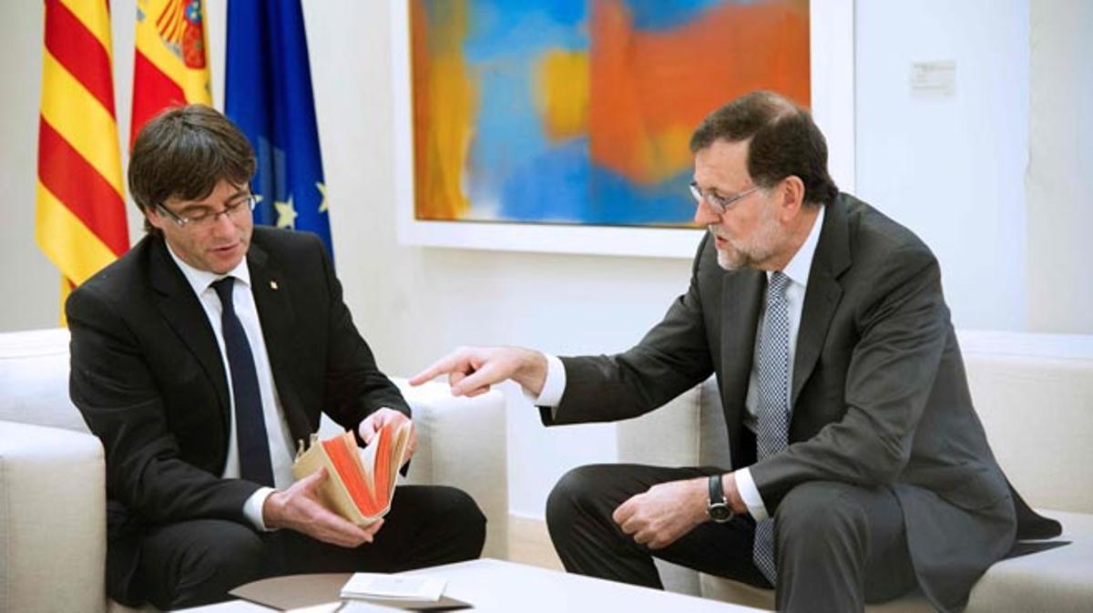 Puigdemont fulleja el fascímil del ’Quijote’ a la Moncloa.