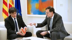 Puigdemont fulleja el fascímil del ’Quijote’ a la Moncloa.