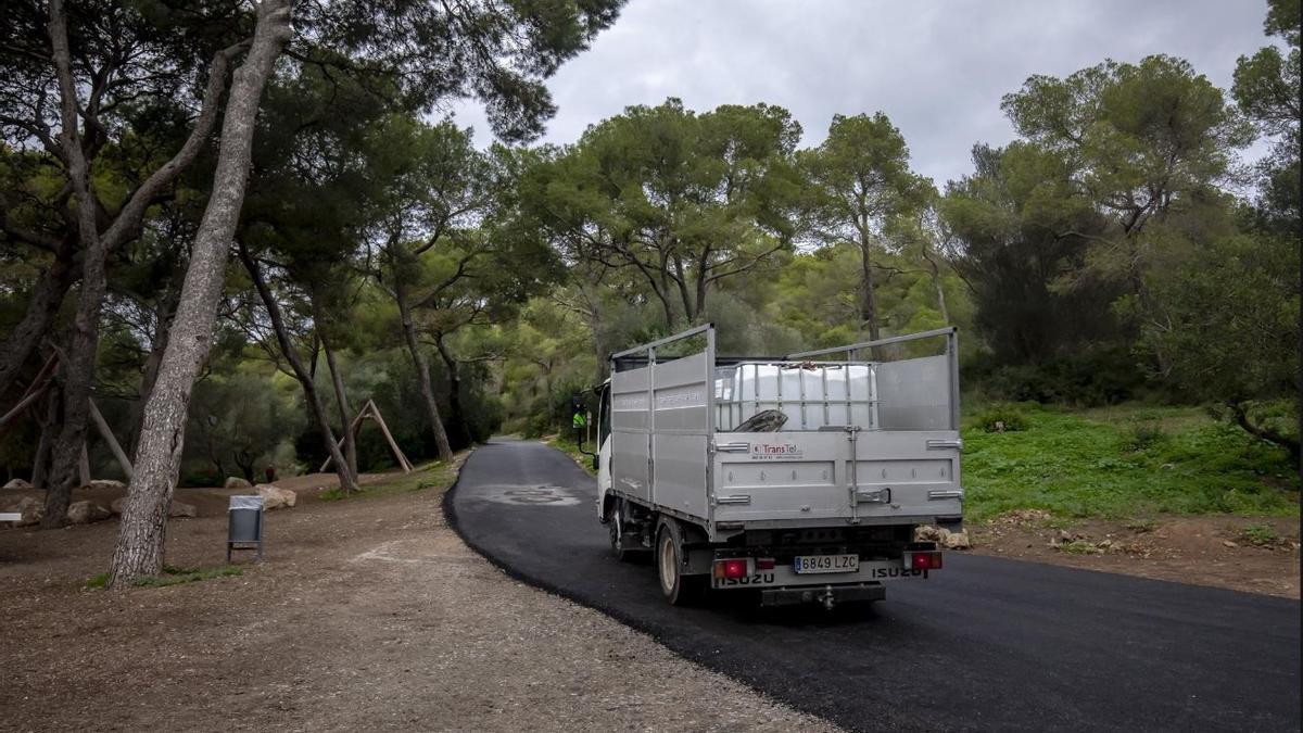 Un camión de servicio circula por el camino recientemente reasfaltado.