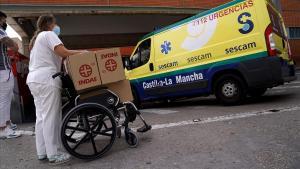 Una sanitaria carga material en una silla de ruedas a las puertas del servicio de Urgencias del Hospital Virgen de la Salud de Toledo.
