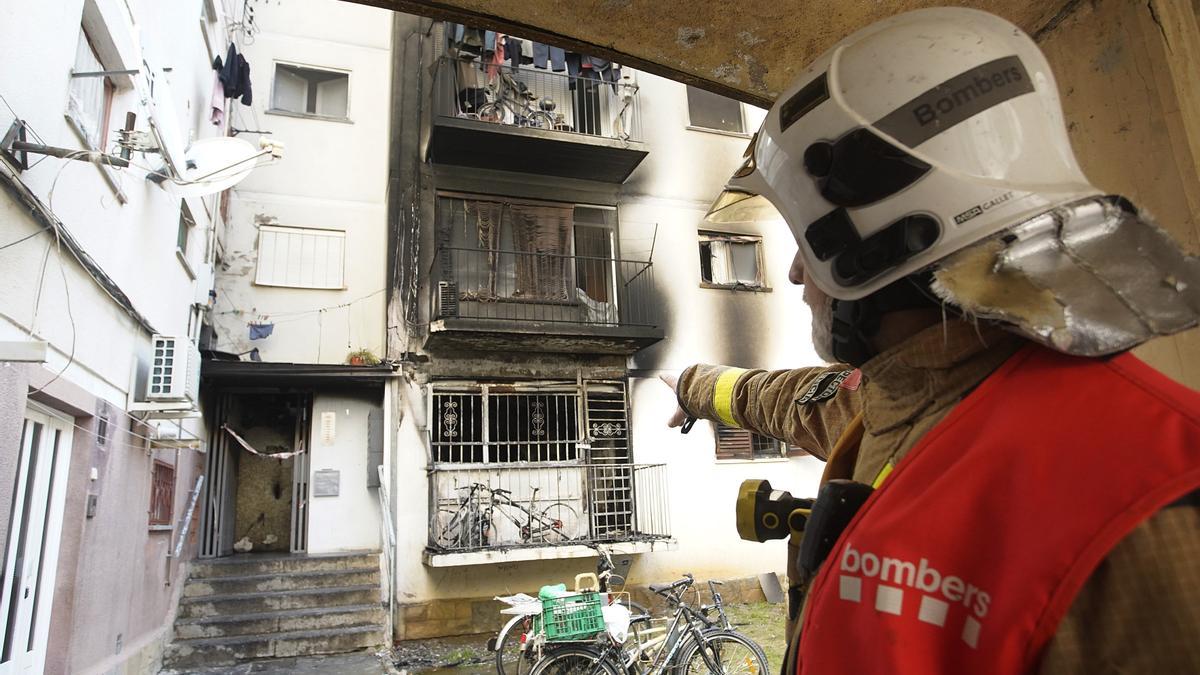Un bomber mostrant els danys d’un incendi a Salt, arxiu.