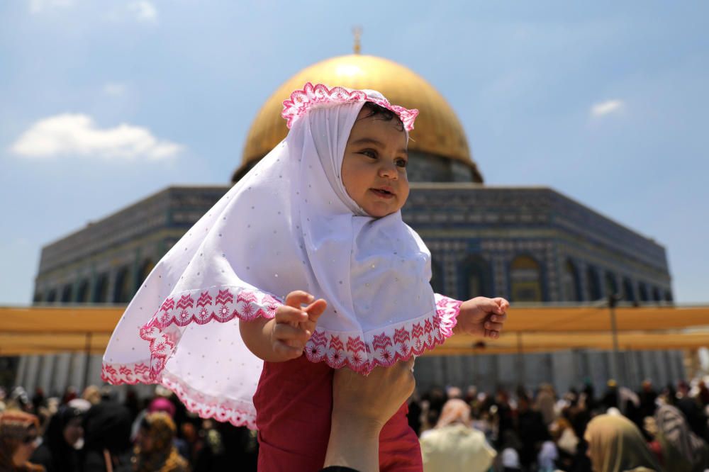 Una mujer palestina levanta a una niña el primer viernes del mes santo de ayuno de Ramadán en Jerusalén. REUTERS.