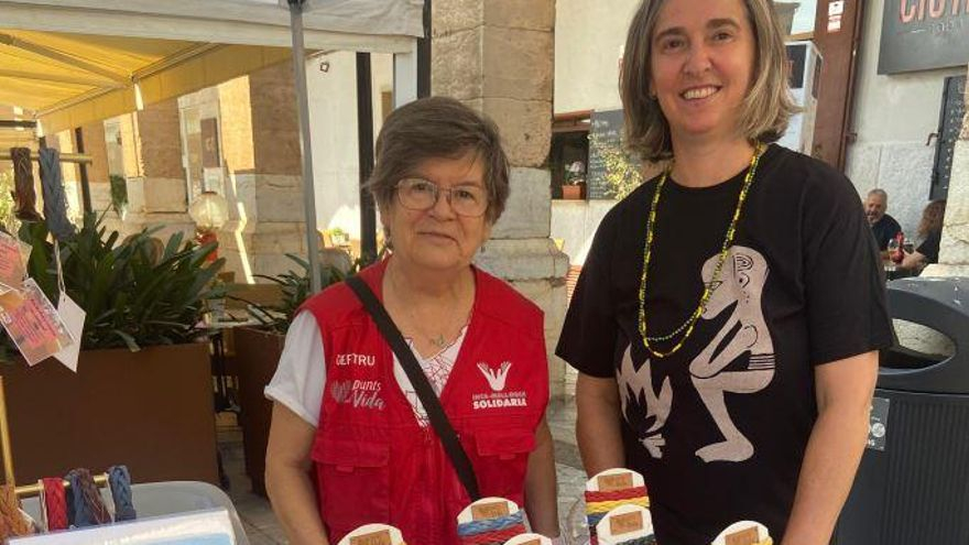 Dos de las integrantes de Punts Amb Vida, en uno de los puestos de venta de las pulseras solidarias.