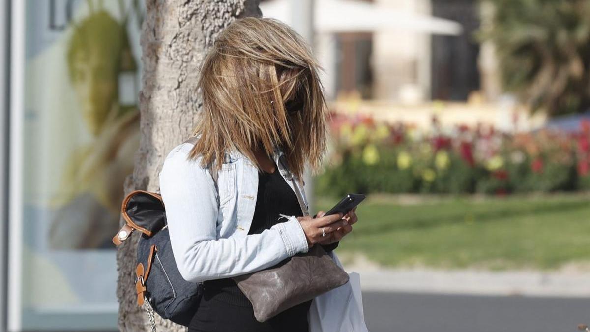 Una mujer &quot;sufre&quot; el fuerte viento en Alicante en una imagen reciente.