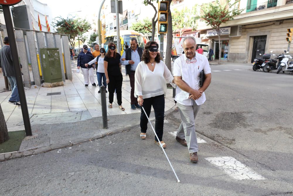 Algunas personas, entre ellos políticos, comprueban las dificultades de moverse por la calle que sufren las personas con discapacidad visual.