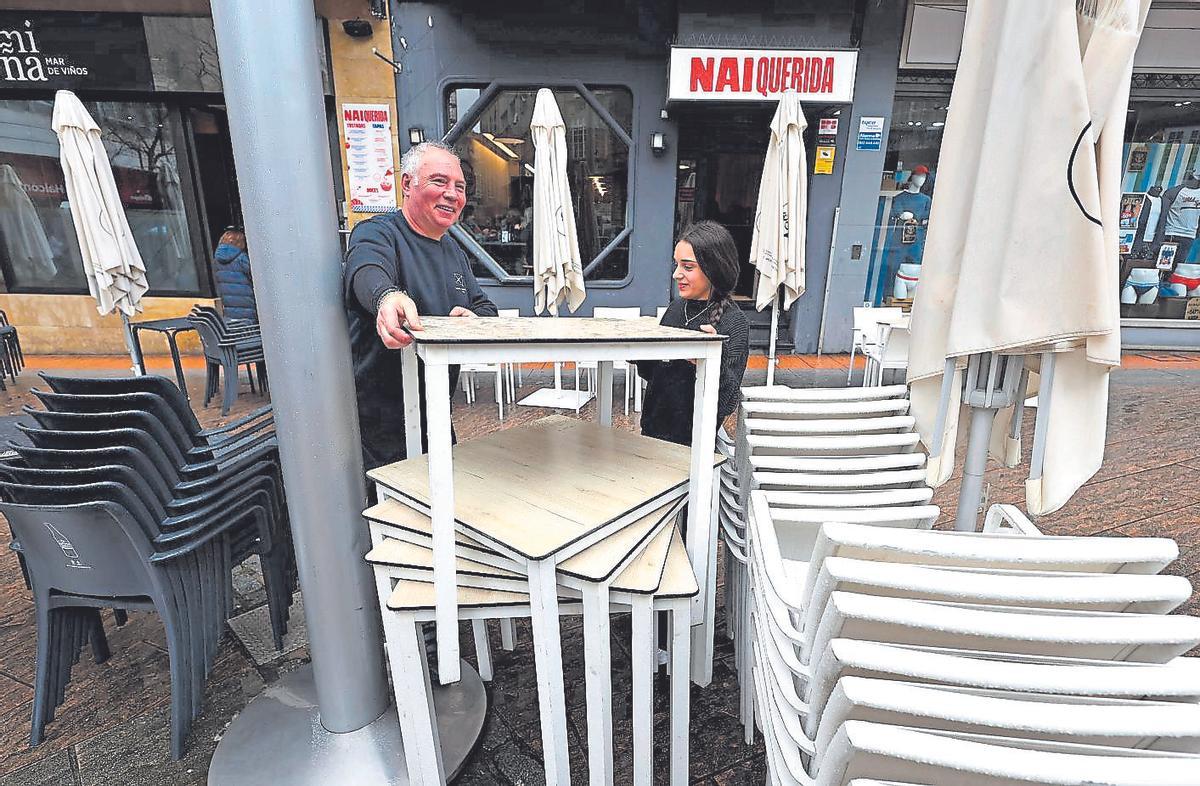 Jorge Pérez, encargado del Miña y Nai Querida, recoge una terraza con una de las camareras.