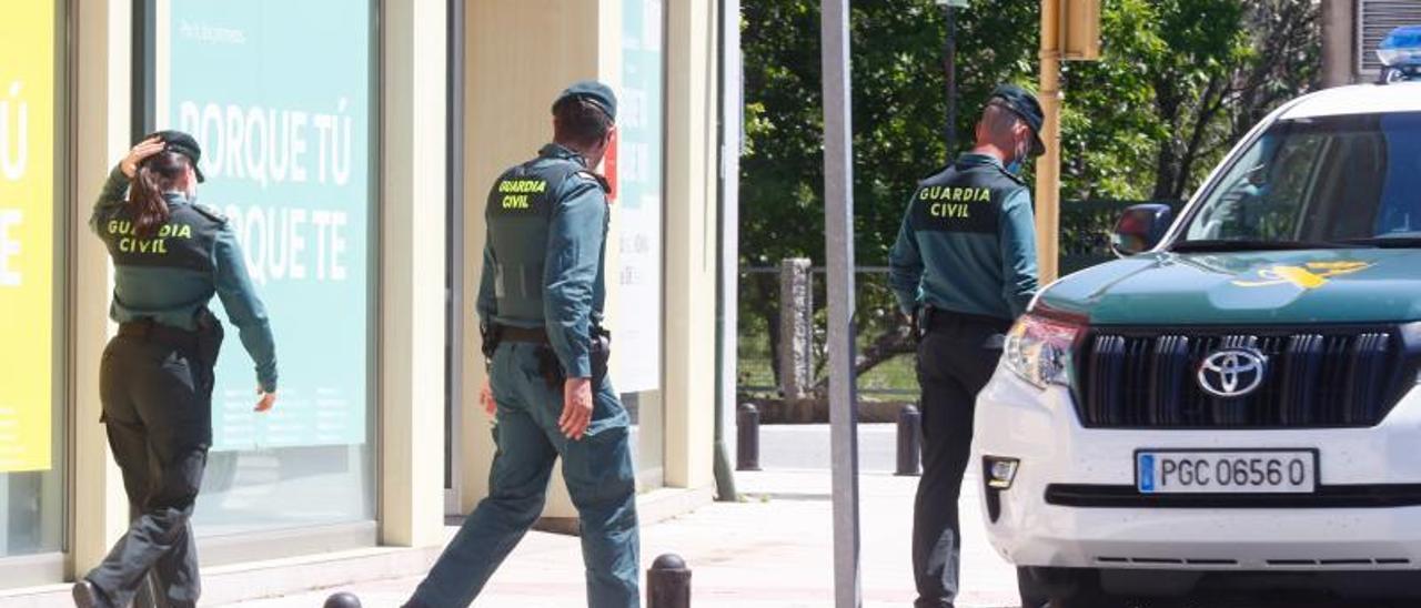 Vehículos y agentes de la Guardia Civil a las puertas de la sucursal bancaria de O Mosteiro.