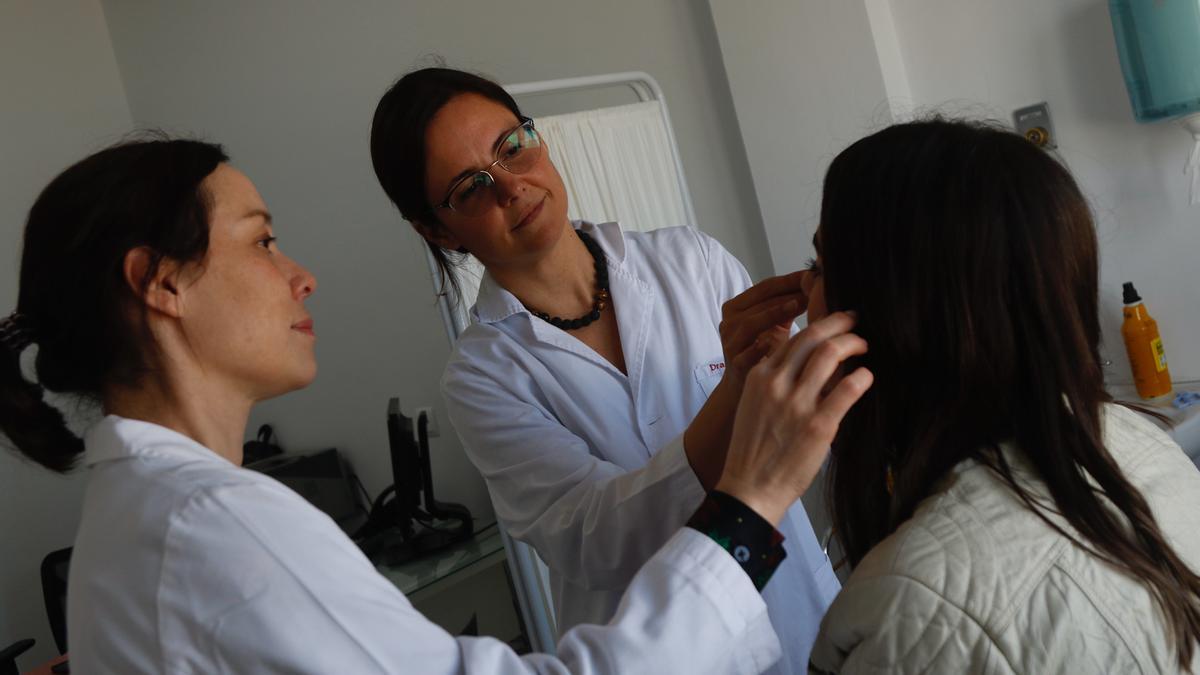 Las doctoras Susana Heredero y Mabel Falguera, del hospital Cruz Roja Córdoba, con una paciente en la consulta de medicina estética.