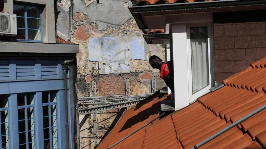 Un bombero observa la colmena en el tejado.