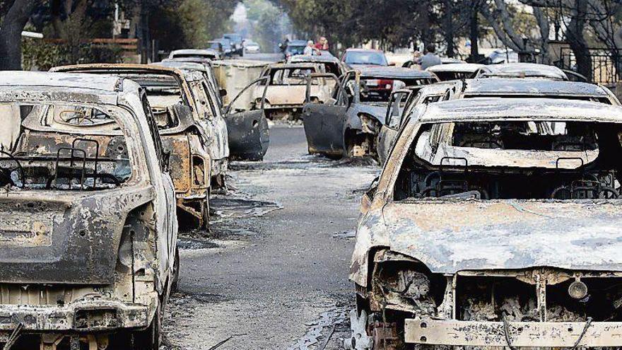 Vehículos calcinados por los incendios en los alrededores de Atenas.