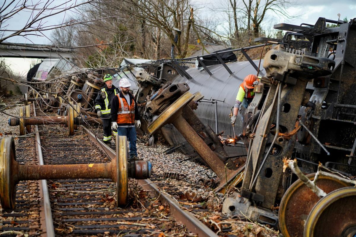 Trabajadores en la escena del descarrilamiento de un tren después de que un devastador brote de tornados arrasara varios estados de EE. UU. En Earlington, Kentucky,