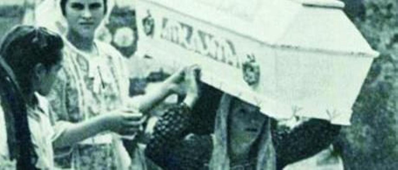 Una mujer porta en procesión un ataúd cerrado, en 1951.