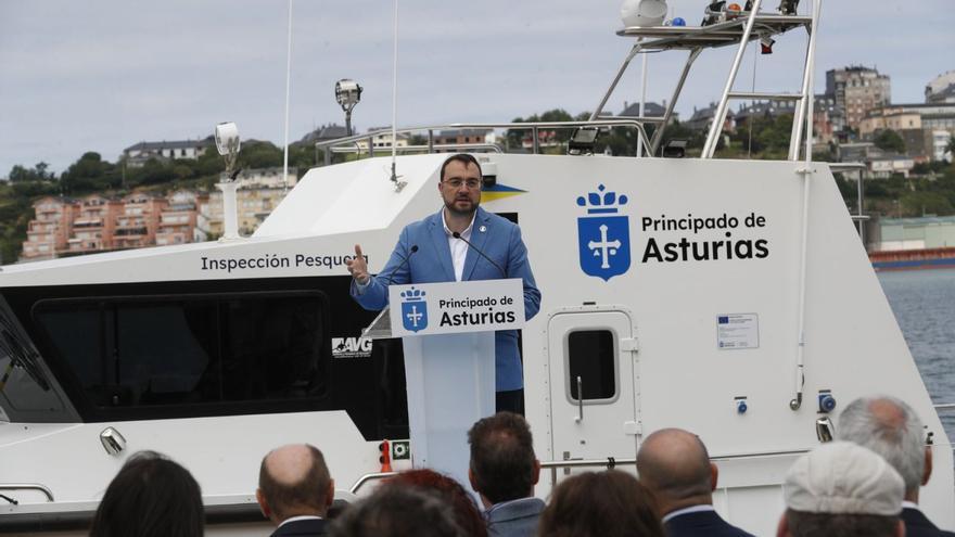 El presidente del Principado, Adrián Barbón, durante su intervención en la presentación de la nueva patrullera de Inspección Pesquera «Ría del Eo», con la embarcación a su espalda, en el puerto de Castropol.
