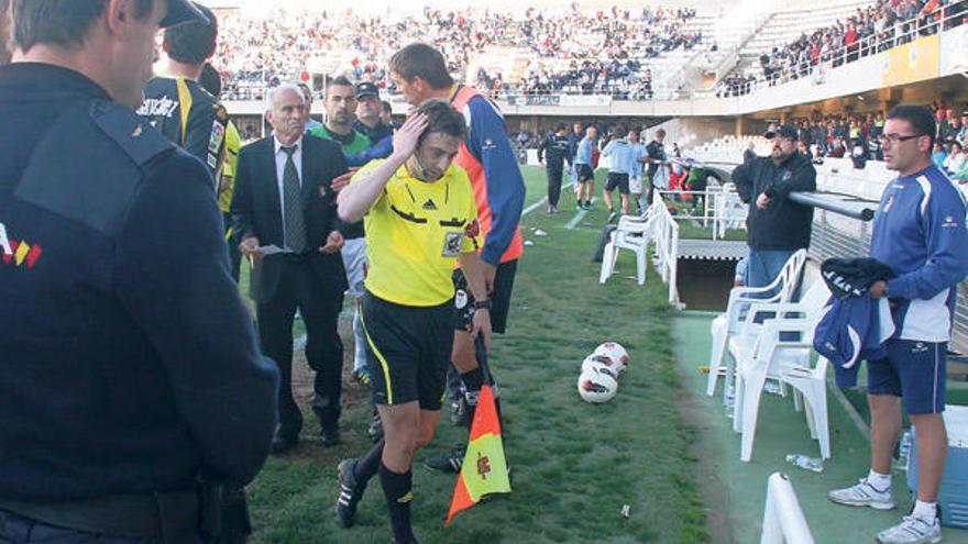 El asistente de Pino Zamorano abandonó el terreno de juego de Cartagonova tapándose con la mano derecha la herida que le provocó el objeto sin identificar que se lanzó desde la grada de Tribuna y que originó la suspensión del partido Cartagena- Celta.