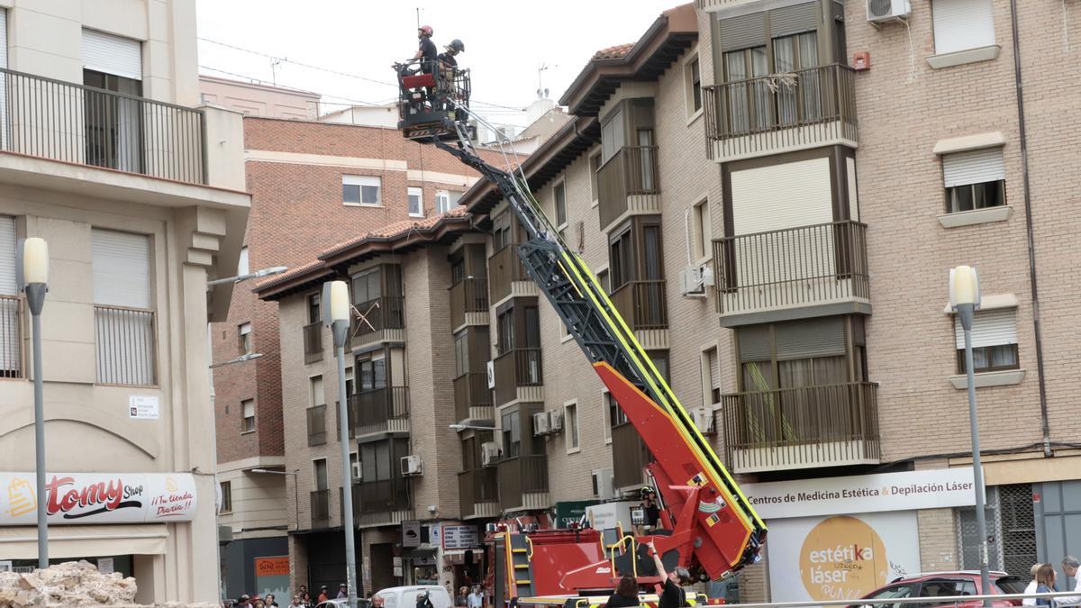 Bomberos se movilizaron en un vehículo escala para sanear y revisar la parte de arriba del edificio tras el derrumbe.