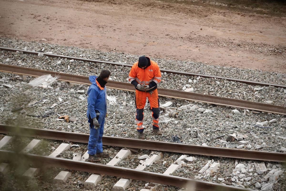 Dos operarios trabajan sobre la vía en la zona cero de Adamuz.