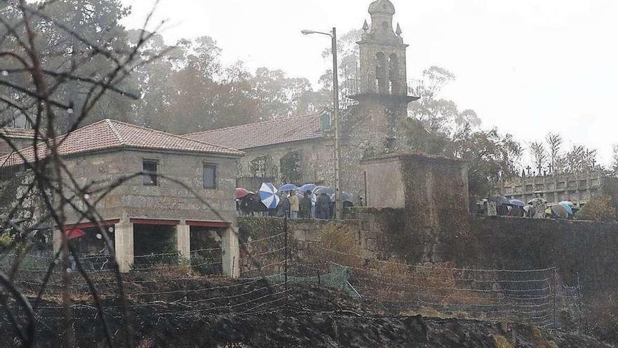 La iglesia de Chandebrito, rodeada de gente y monte quemado, ayer durante el funeral.