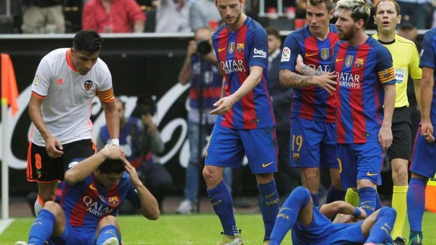 Luis Suárez y Neymar, en el suelo a raíz del lanzamiento de una botella tras el gol de penalti de Messi.