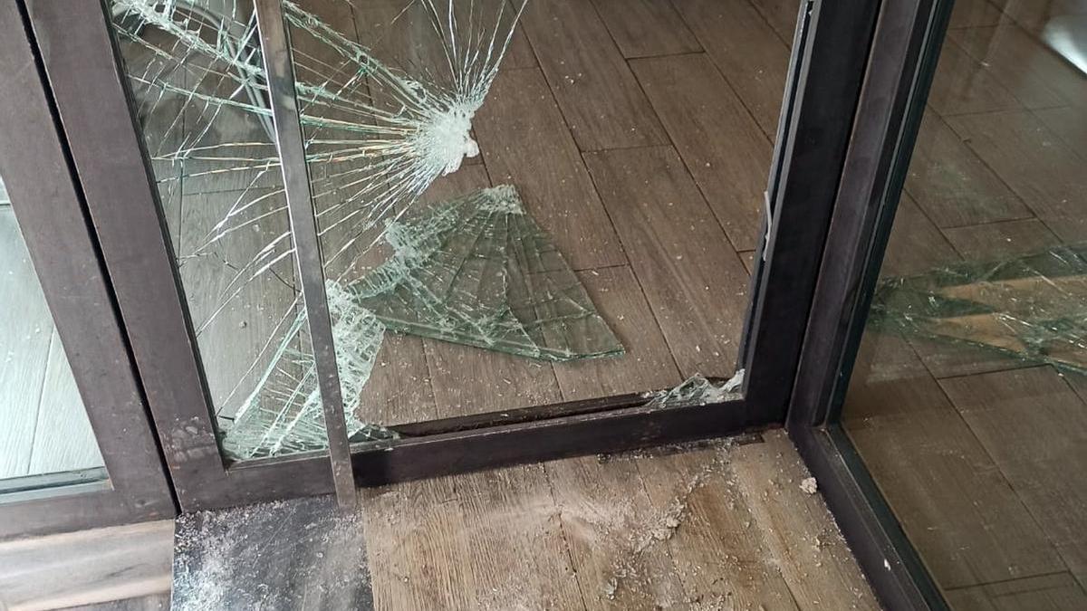 Cristal roto de una puerta de uno de los comercios en los que robaron