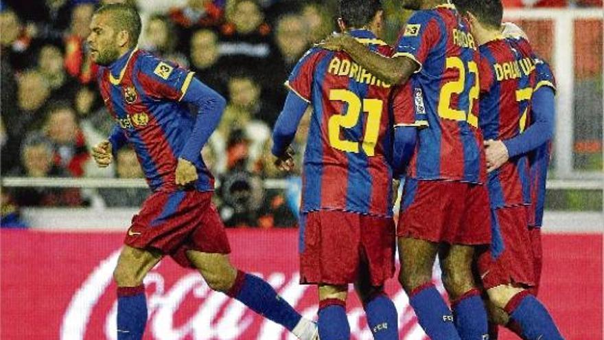 Adriano, Abidal i David Villa feliciten Leo Messi, autor ahir de l&#039;únic gol del Barcelona al camp del València.