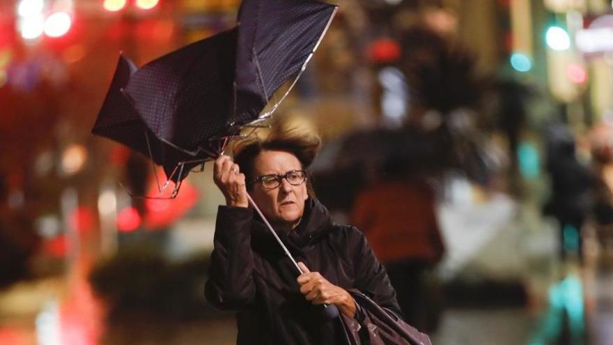 Una vecina de Vigo se protege del viento. // R. Grobas