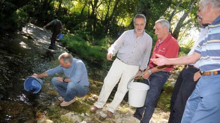 Balseiros y Cores Tourís en la suelta de alevines que tuvo lugar en la playa fluvial.  // Bernabé/Javier Lalín