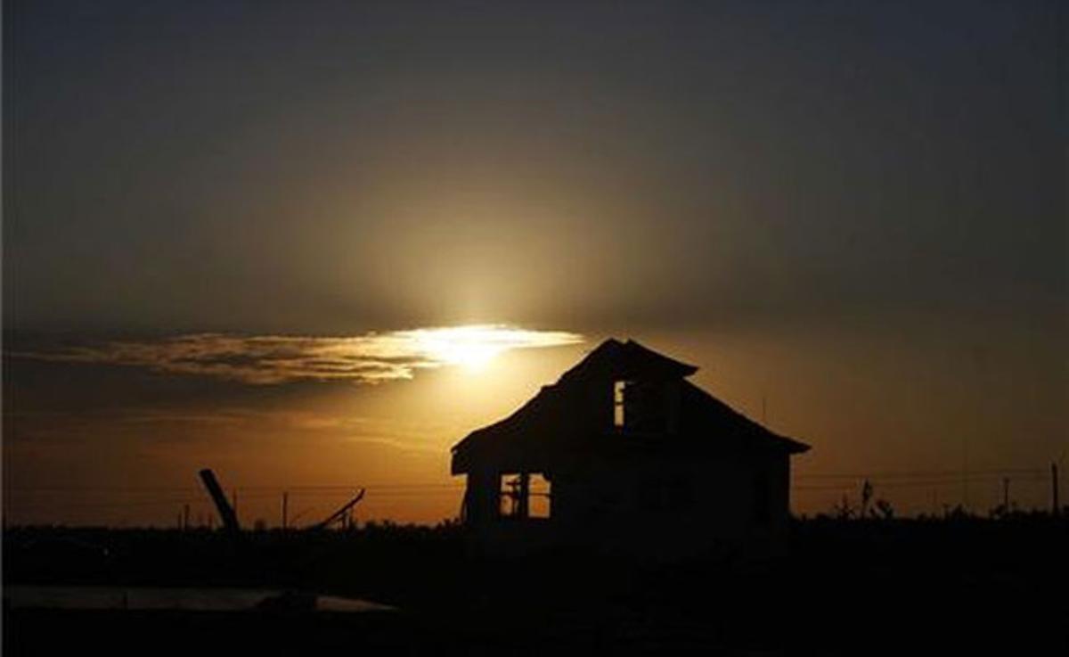 Una casa devastada pel tornadoJoplin es veu al fons, en la foscor de Missouri (EUA).