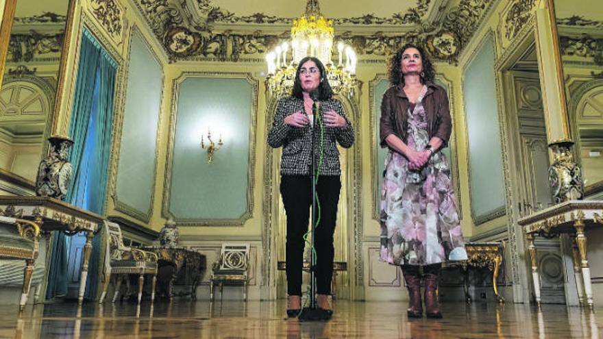 La ministra de Política Territorial, Carolina Darias (i), y la de Hacienda, María Jesús Montero, al término de la reunión con la comisión de administraciones locales.