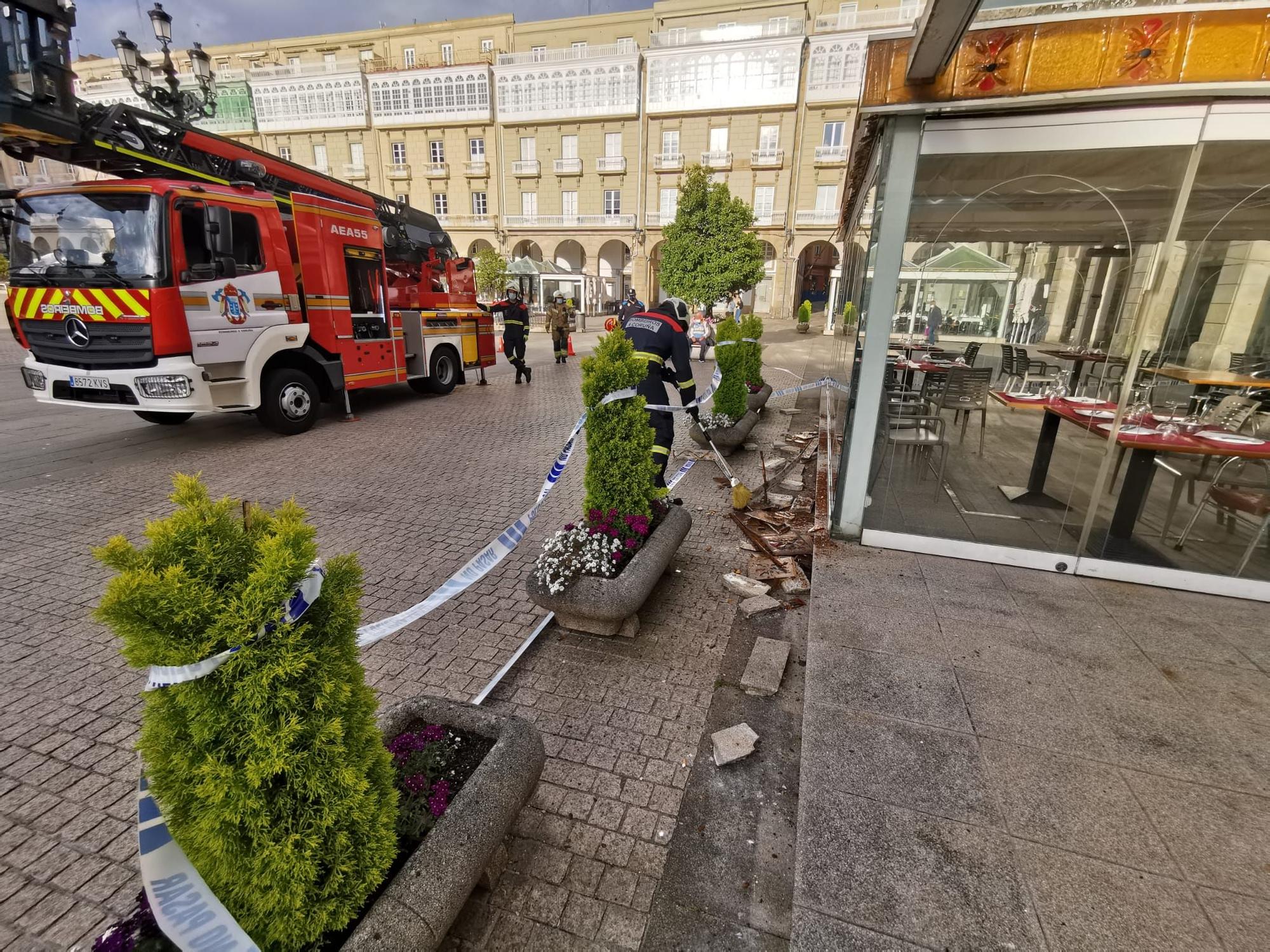 Los bomberos acuden a la plaza de María Pita a reparar el friso decorativo de la terraza de la pizzería Cambalache