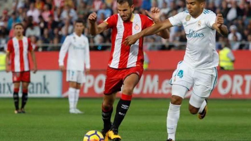 Cristhian Stuani protegeix la pilota davant la pressió de Casemiro, del Reial Madrid.