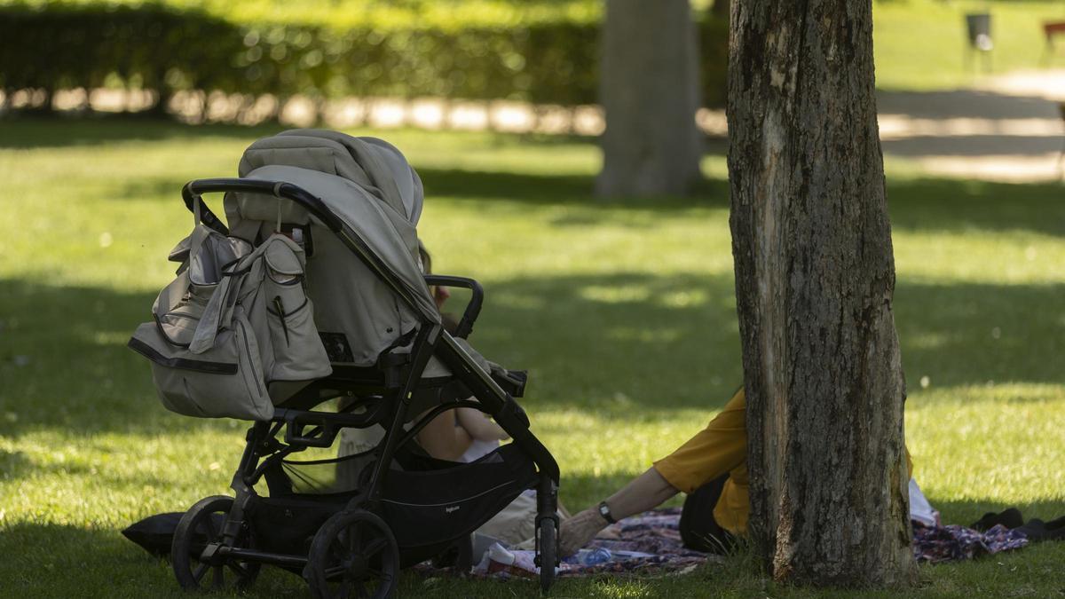 Un familiar cuida de un bebé en un parque, en imagen de archivo.