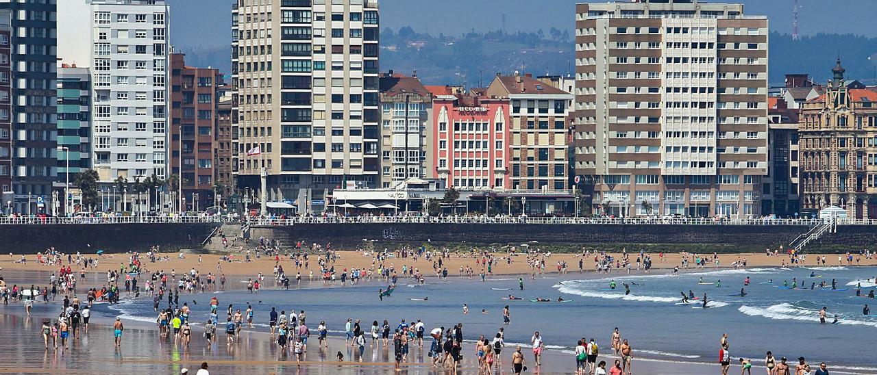 Bañistas y paseantes en la playa de San Lorenzo.