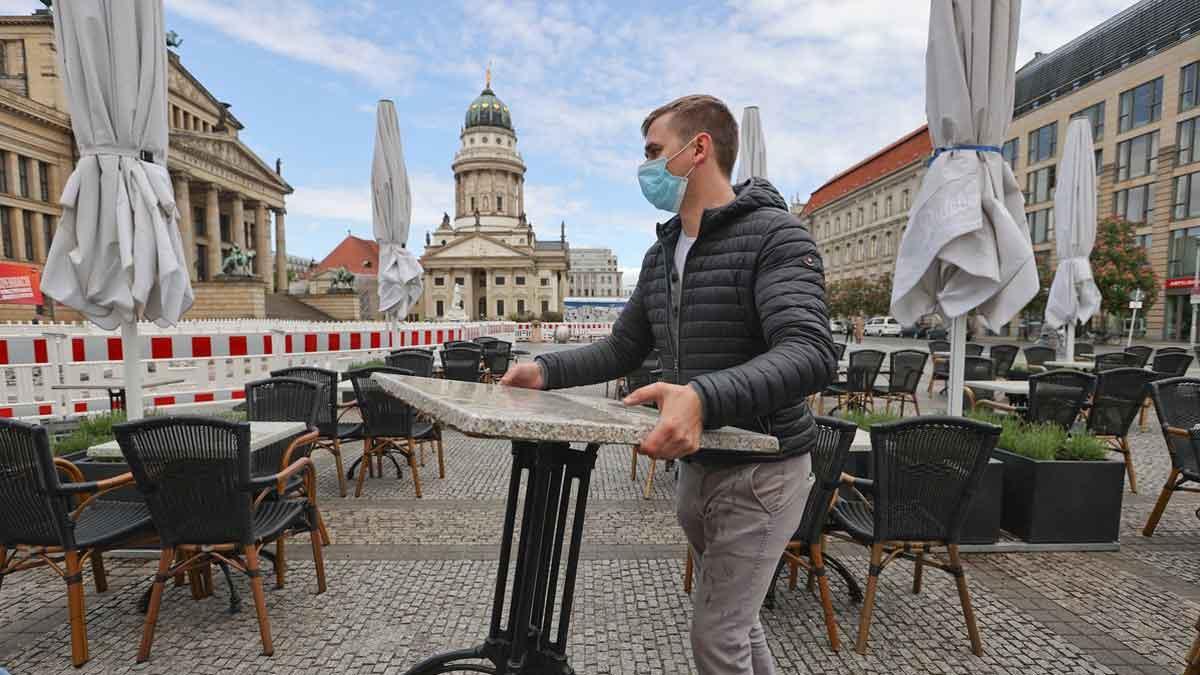 Alemania registra un máximo diario de 410 muertos por coronavirus. En la foto, un camarero ordena las mesas de su bar, en Berlín.