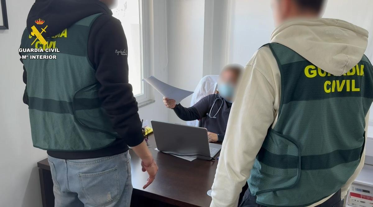 Dos agentes de la guardia civil recibiendo un informe médico.
