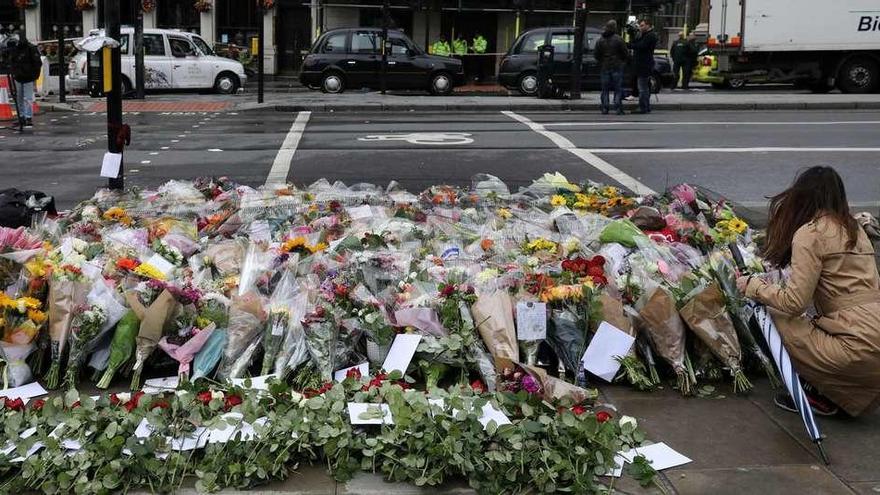 Una mujer deposita un ramo de flores en la zona de los ataques. // Reuters