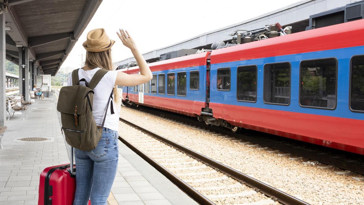 Una joven espera un tren en una estacion europea.