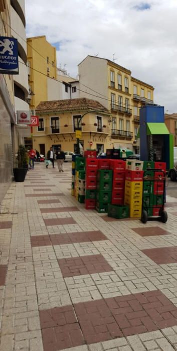 Una acera de la calle Carretería, prácticamente cortada por mercancias.