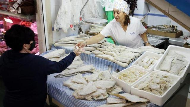 Una clienta comprando en el mercado de O Calvario.