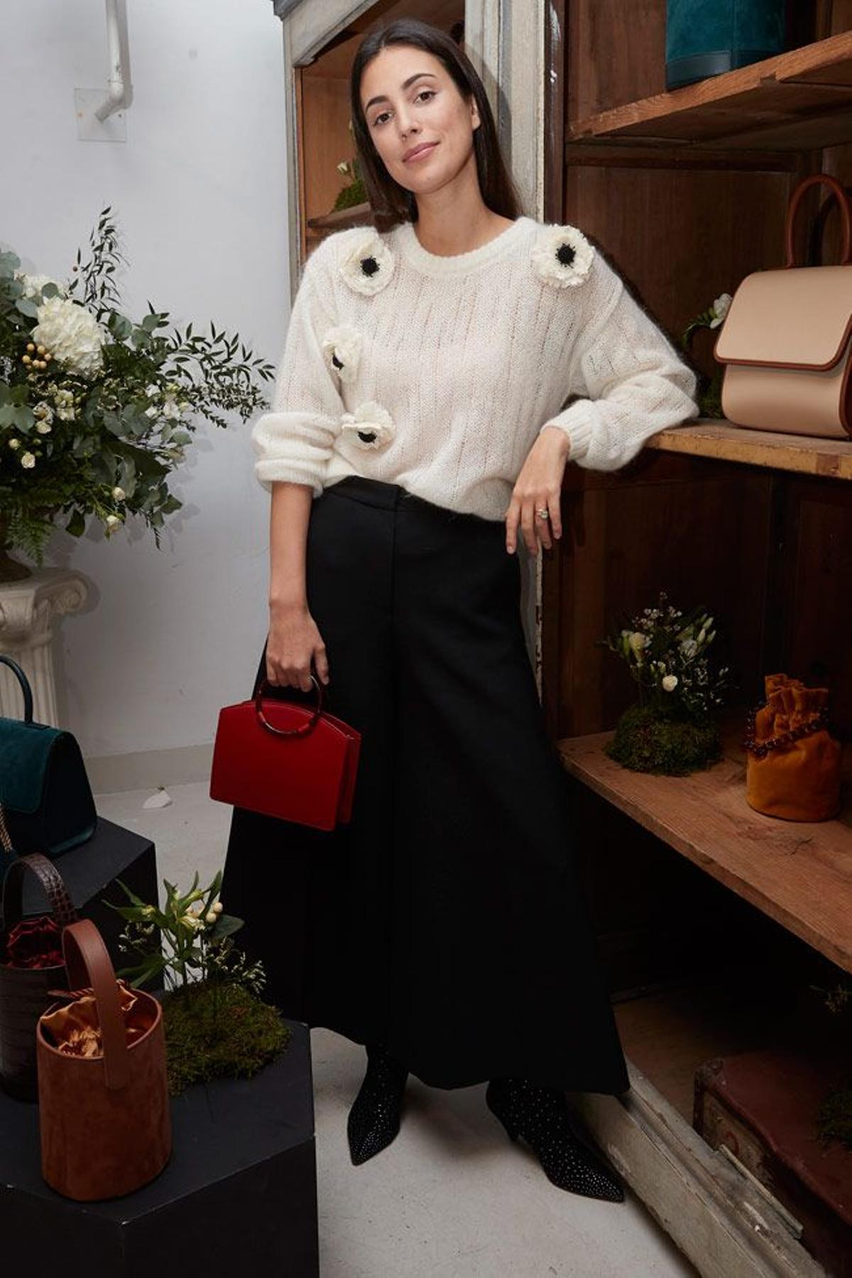 El look de Alessandra de Osma con jersey de flores en 3D, pantalón negro, botas altas y bolso de Moi&Sass