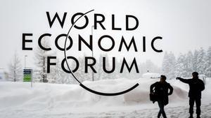 Dos miembros de seguridad frente al cartel del World Economic Forum.