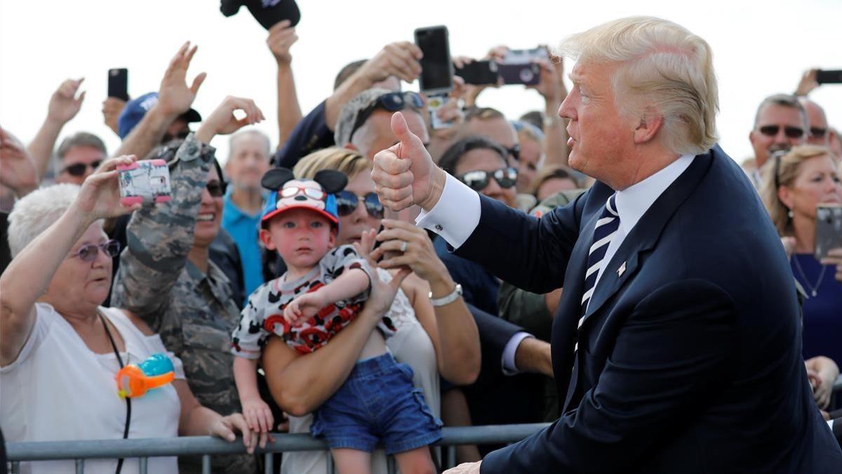 El presidente Trump saluda a su llegada al aeropuerto de Charlotte, el viernes.