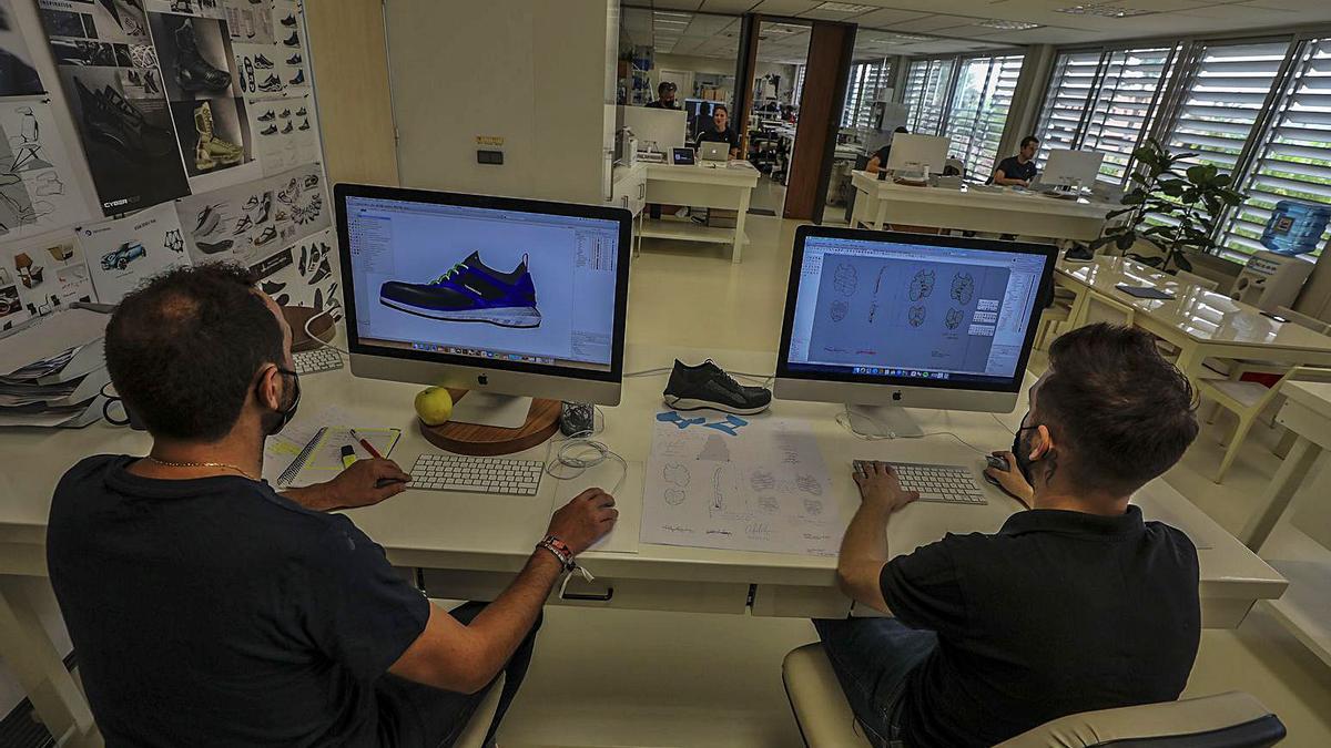 Dos de los empleados de la firma trabajan en el diseño de unos modelos. | Antonio Amorós