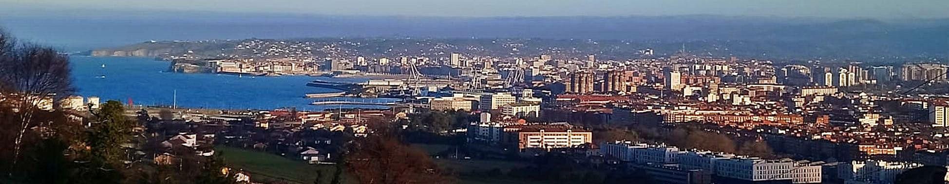 Vista de Gijón desde el alto de la parroquia de Veriña y, en el círculo, un hórreo en Tremañes. 