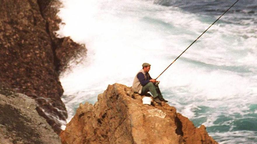 Un pescador en las piedras de San Juan de Nieva.