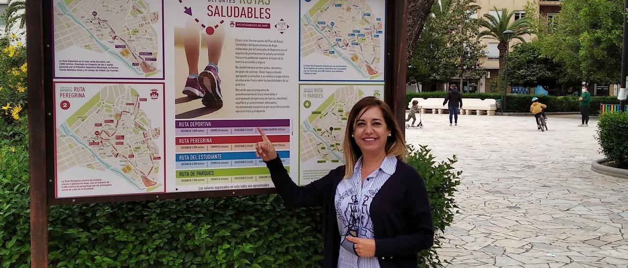 La concejala de Deportes mostrando el panel informativo de las Rutas Saludables de Aspe.