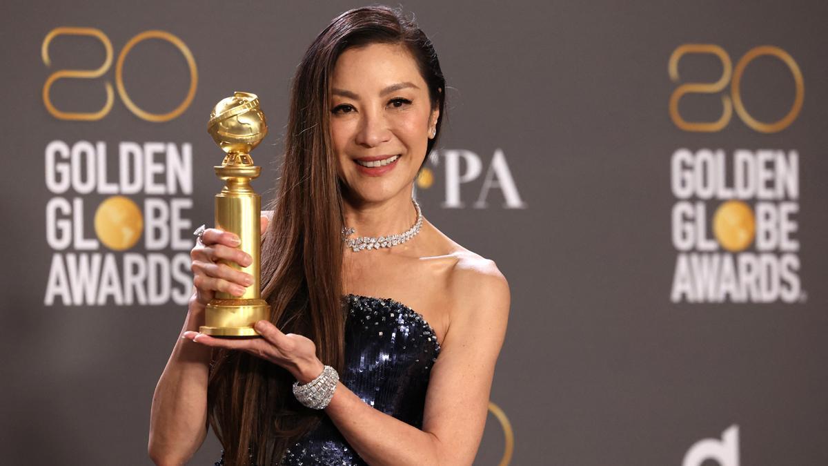 Michelle Yeoh posa con su premio a mejor actriz en un musical o en una película de comedia.