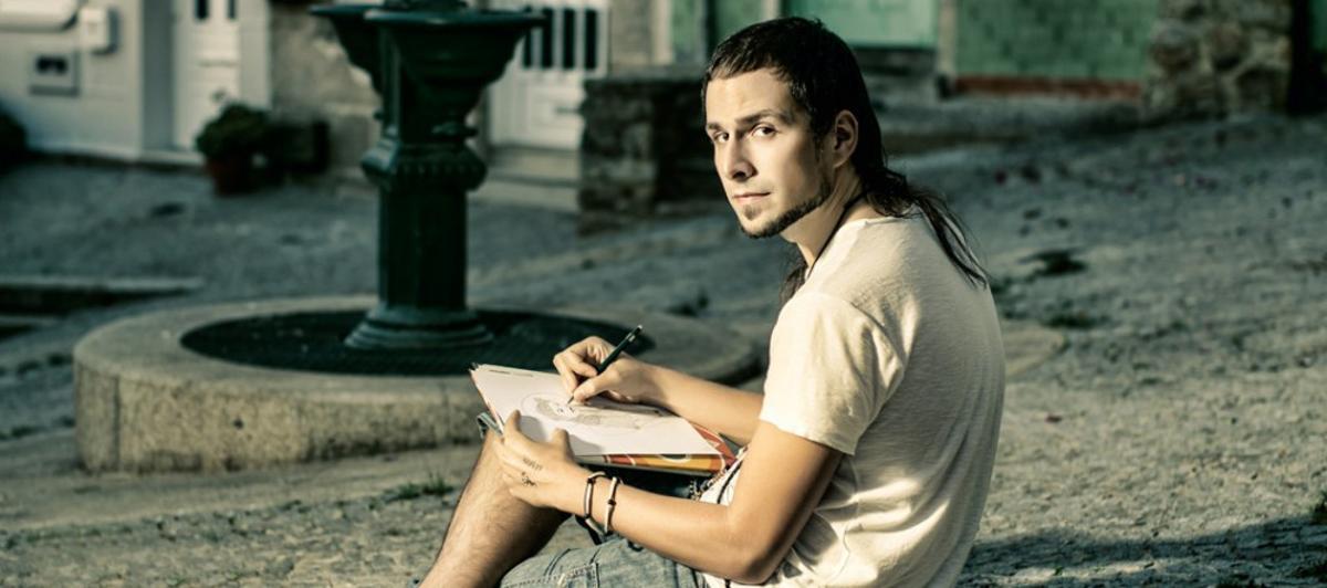 El artista David Amoedo, posando mientras realiza un boceto