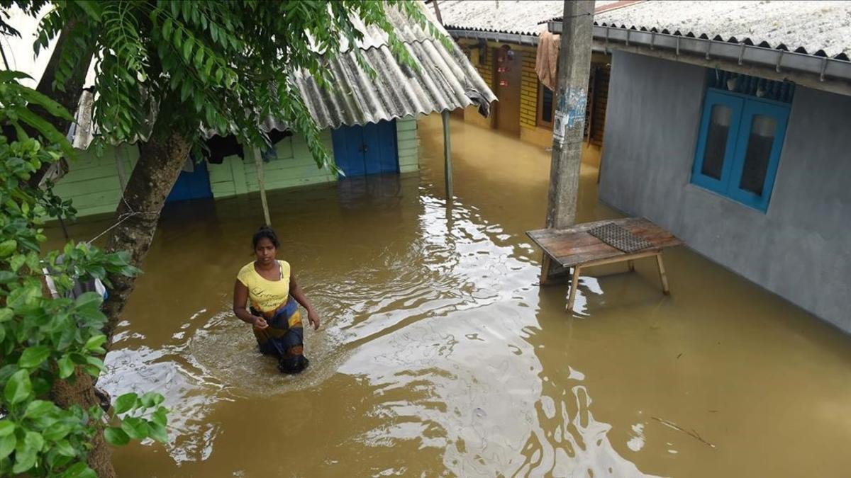 Una mujer se abre apso entre el agua en el suburbio de Kelaya, en Colombo.